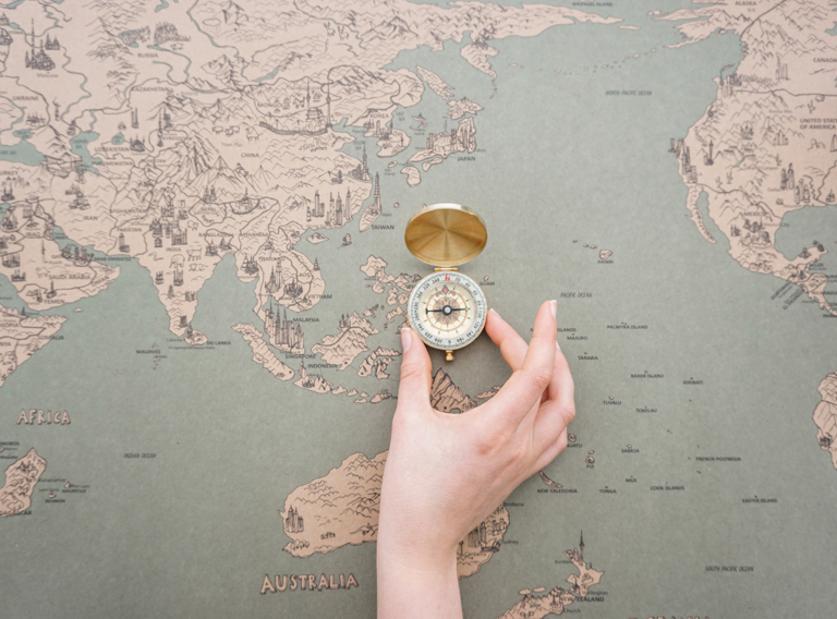 Hand Placing Compass World Map